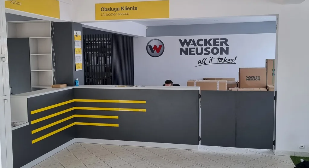 Recepcja oddziału Wacker Neuson z logo i grafikami na ścianach