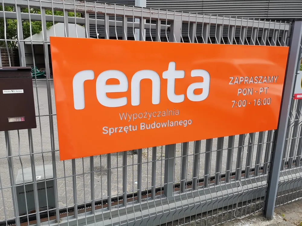Baner reklamowy z danymi kontaktowymi zamontowany na ogrodzeniu