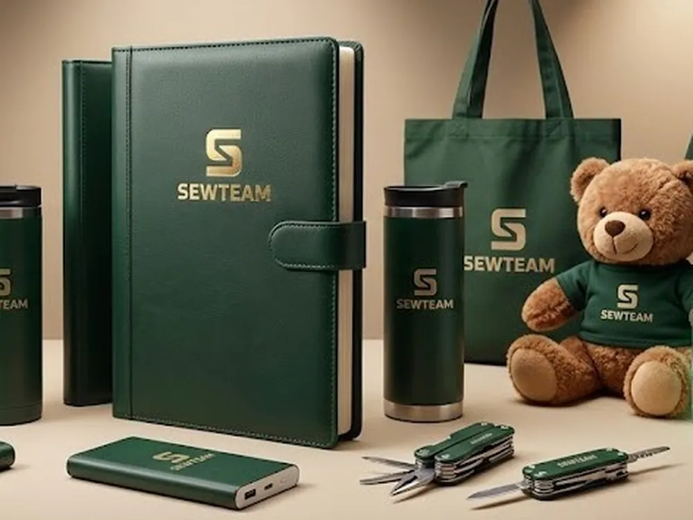 Zdjęcie zestawu gadżetów firmowych: notes, kubek termiczny i torba z logo