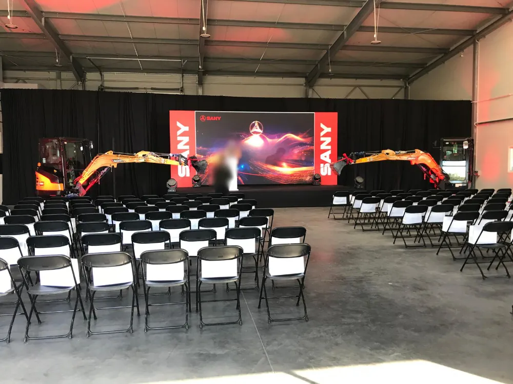 Sala eventowa z podświetloną sceną i ekranami podczas wydarzenia firmowego