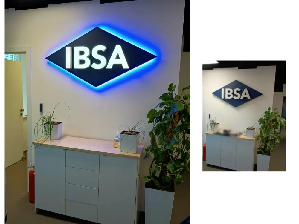 Podświetlane logo firmy na ścianie recepcji w biurze