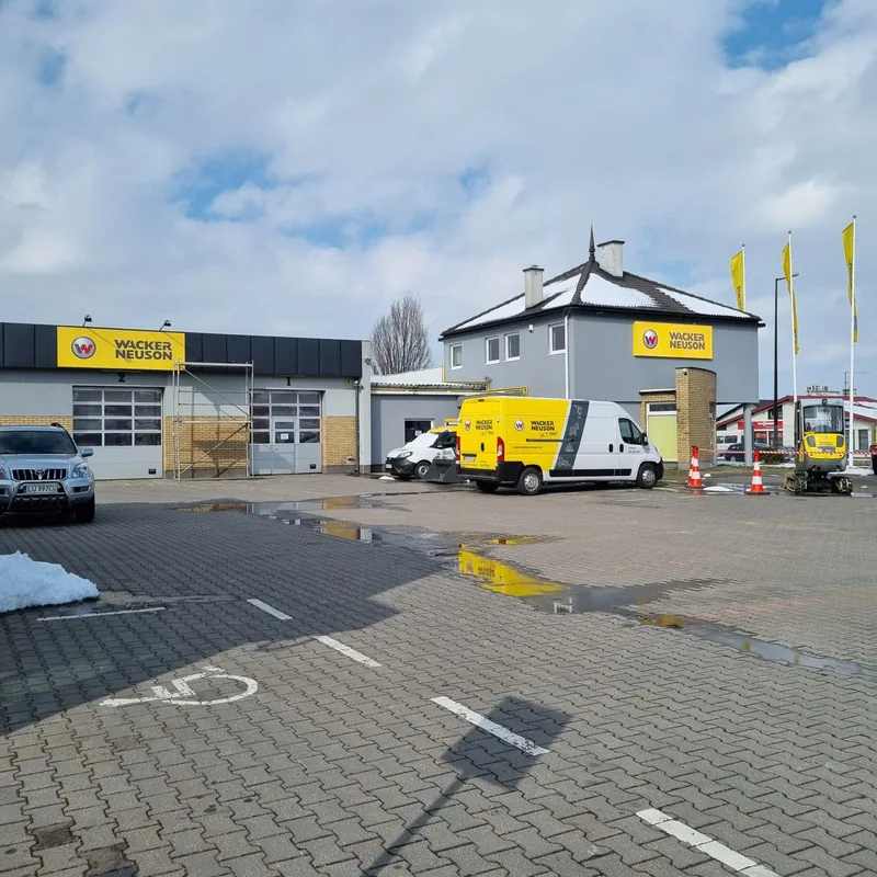 Teren oddziału Wacker Neuson: oznakowanie budynku i oklejone auta