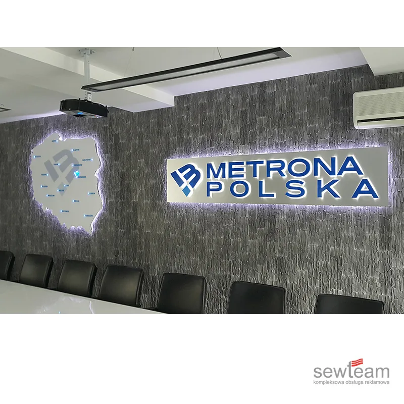 Podświetlane litery Metrona Polska na ścianie z kamienia