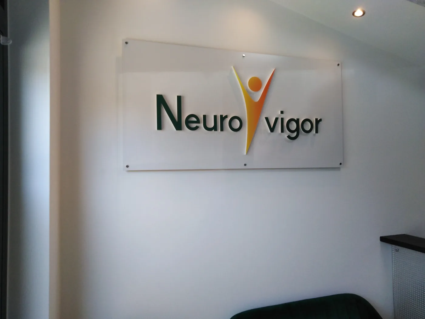 Logo NeuroVigor na pleksi w poczekalni poradni